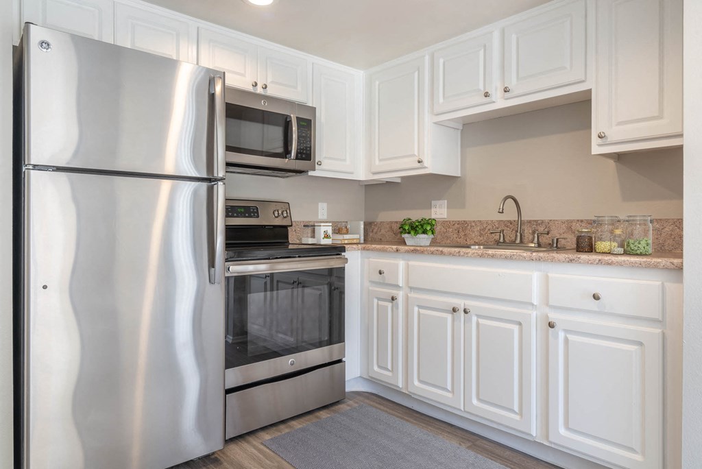 a kitchen with stainless steel appliances and white cabinets