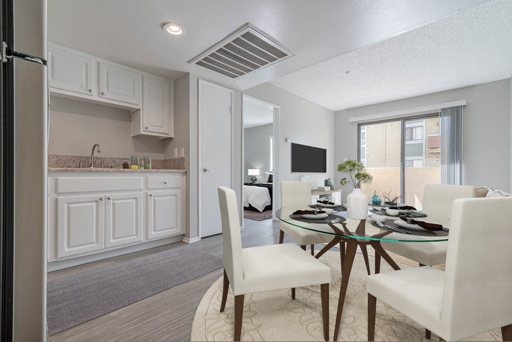 a dining room and kitchen with white cabinets and a table