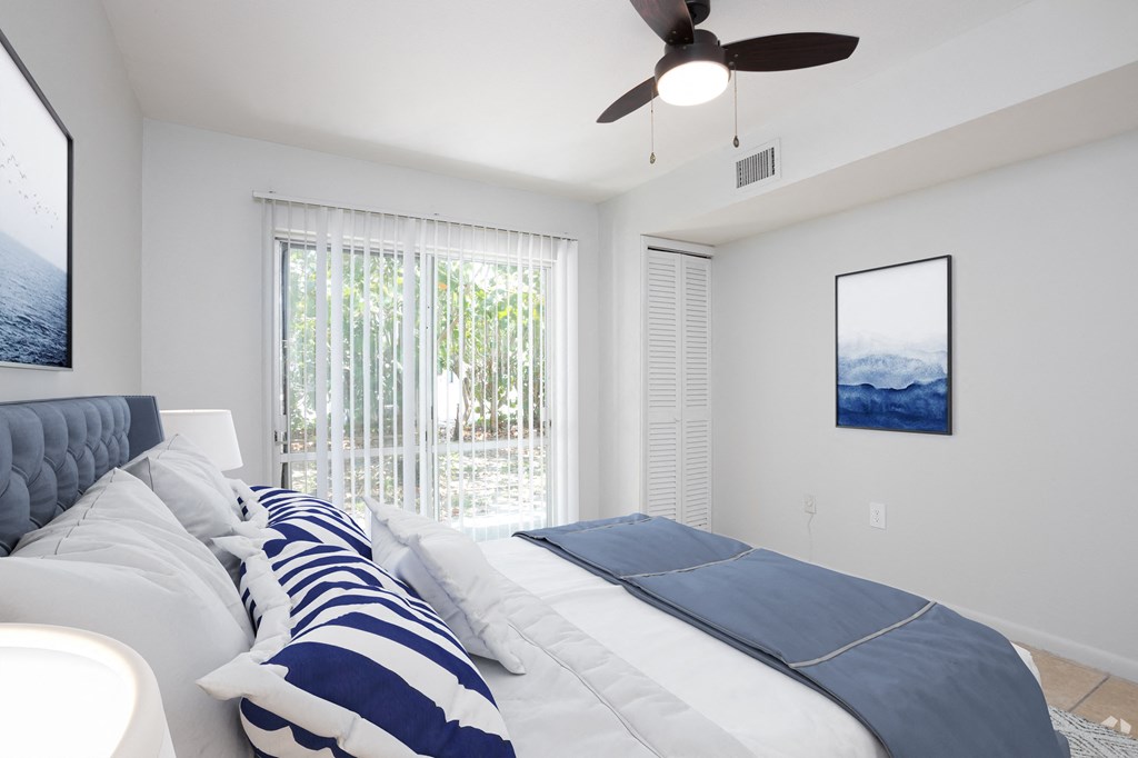 a bedroom with a large bed and a ceiling fan