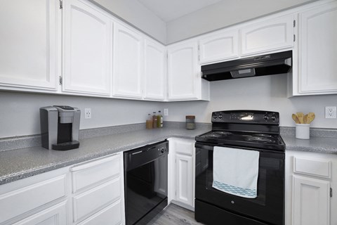 a kitchen with white cabinets and black appliances