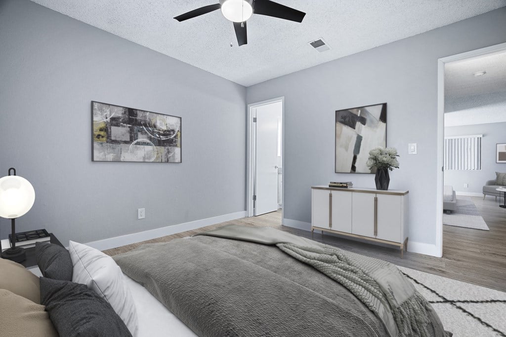 A bedroom with a bed, a ceiling fan, and a cabinet.