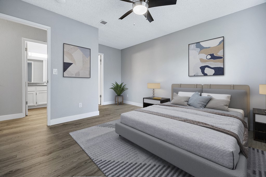 A bedroom with a large bed and a ceiling fan.