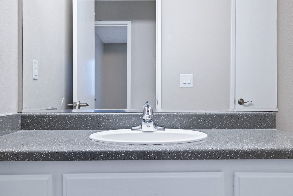 an empty bathroom with a sink and a mirror