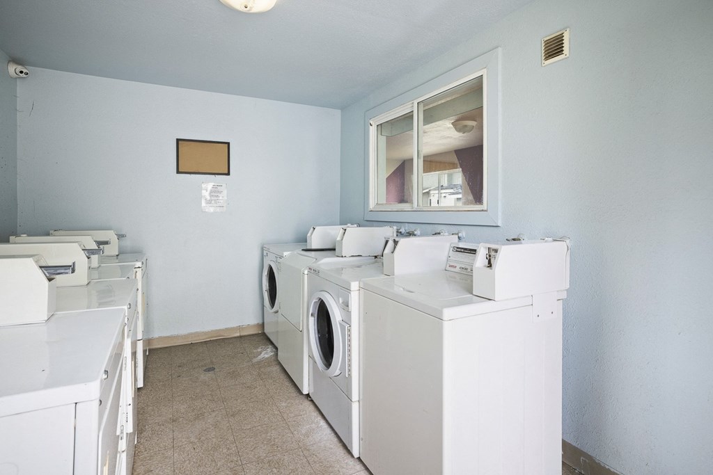 a washer and dryer room with a row of washing machines