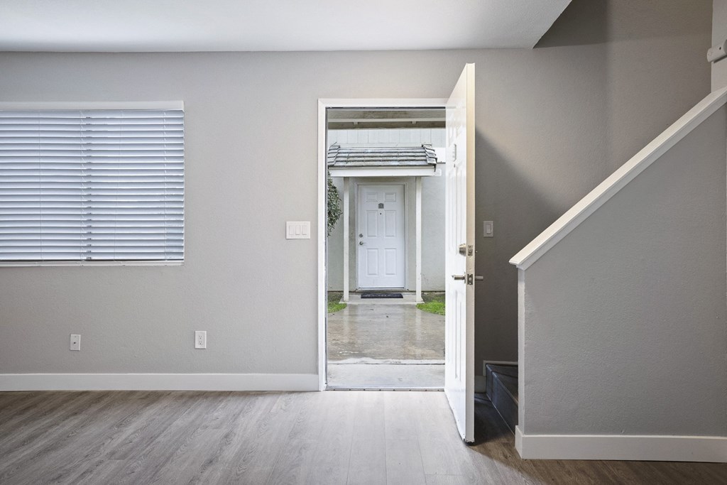 an open door leading to a hallway with a door way to a white door