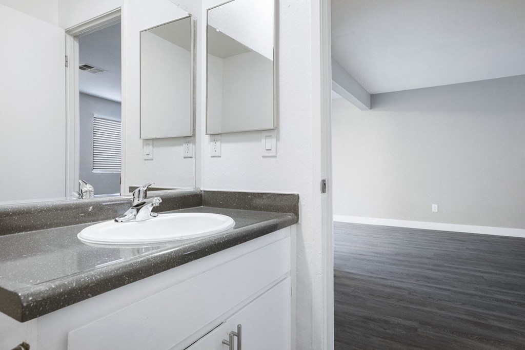 an empty bathroom with a sink and a mirror