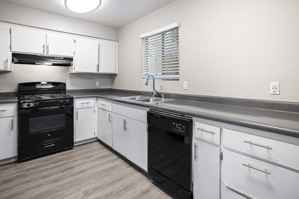 a kitchen with white cabinets and black appliances and a sink