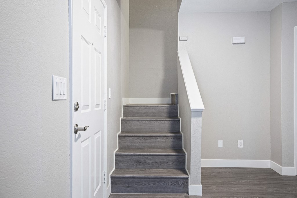a view of the stairs of a home with a white door