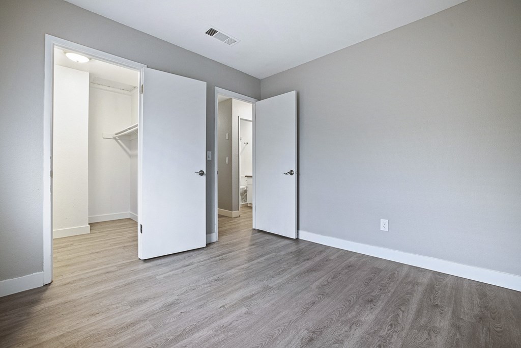 an empty living room with white walls and wood flooring