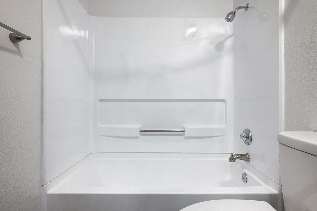 a white bathroom with a tub and a toilet