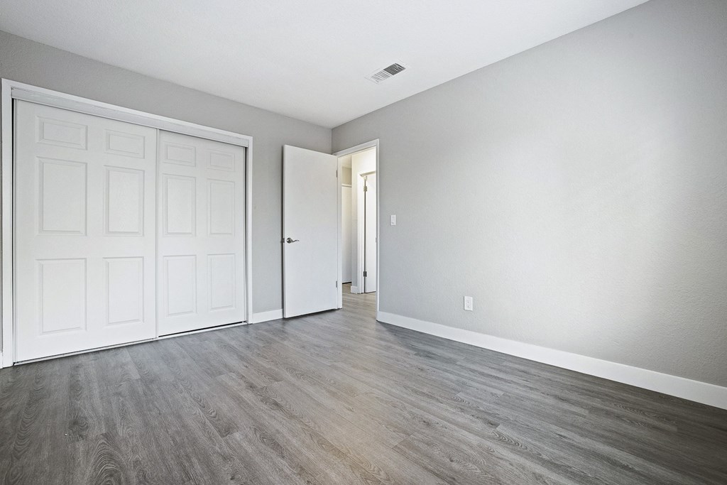 an empty living room with white walls and wood floors