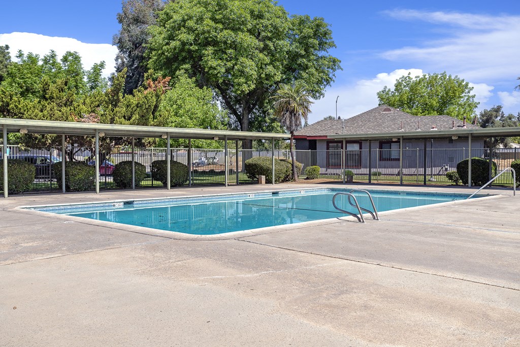 a swimming pool with a fence around it and a building in the background