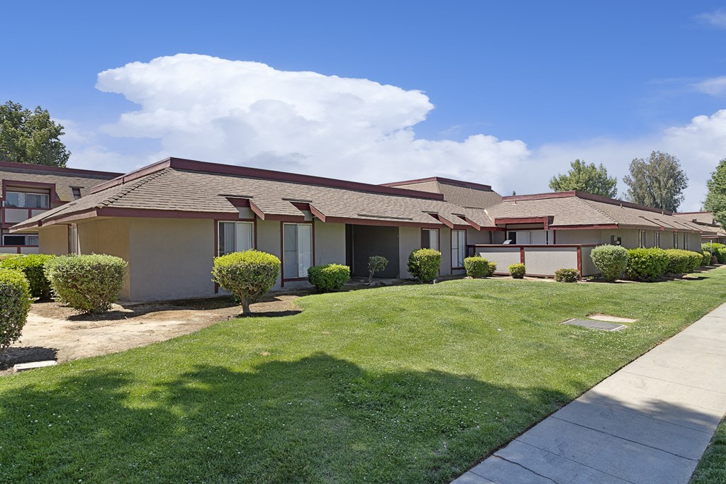 a house with a yard and a sidewalk in front of it