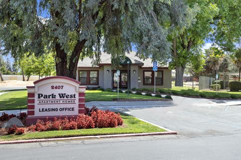 the entrance to park west elementary school with trees and a sign in front of it