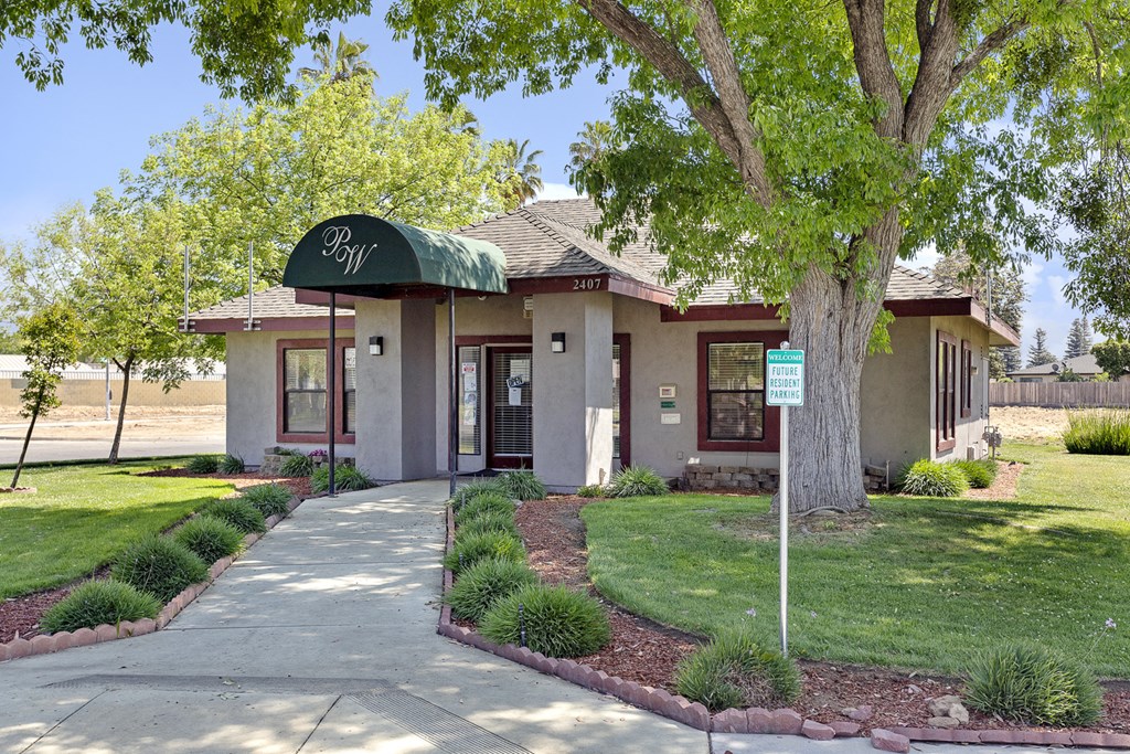 a small building with a green awning and a tree