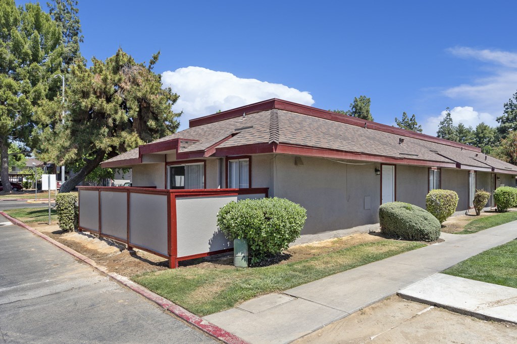 a white house with a red roof and a sidewalk
