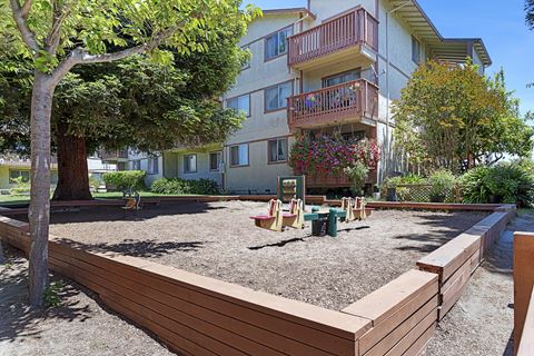 an outdoor play area in front of an apartment building