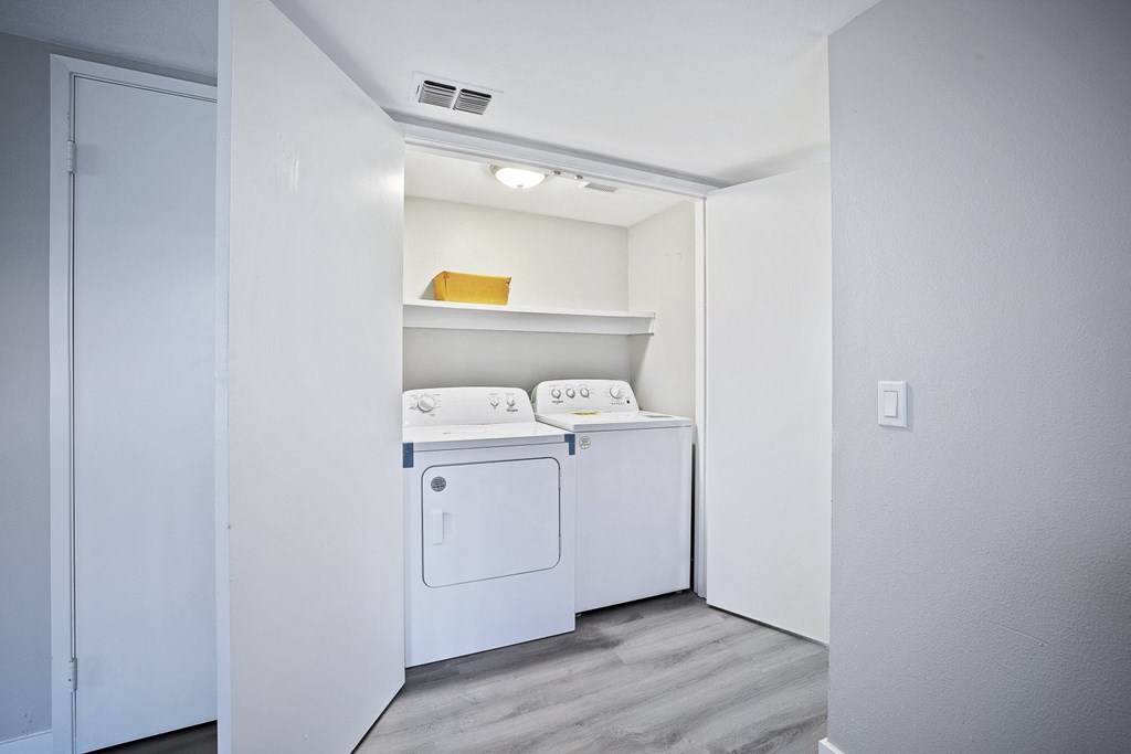 an empty laundry room with a washer and dryer in it