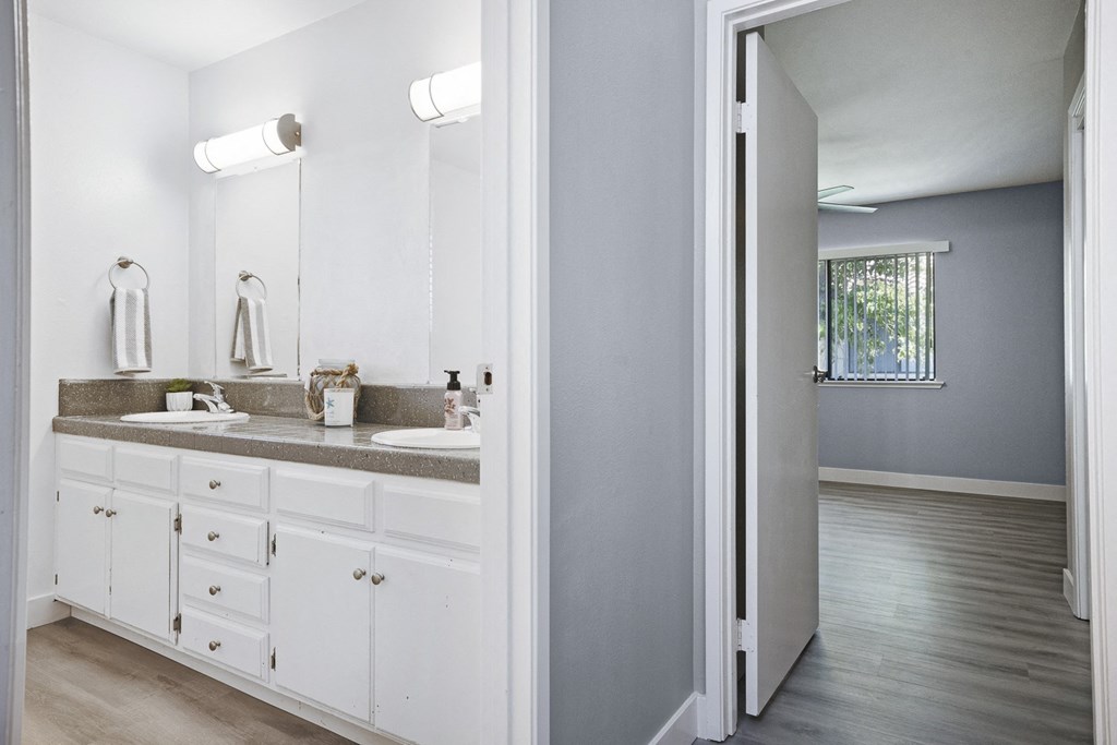 a bathroom with white cabinets and a sink and a mirror
