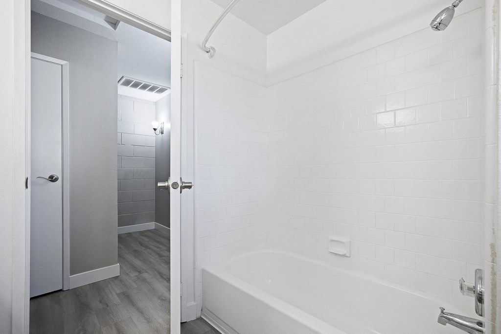 a bathroom with a white tub and a shower and a door