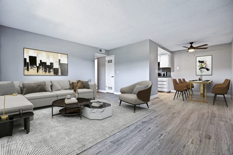 A living room with a grey couch, a coffee table, and a painting on the wall.