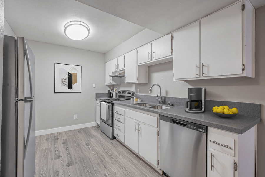 A kitchen with a refrigerator, stove, and microwave.