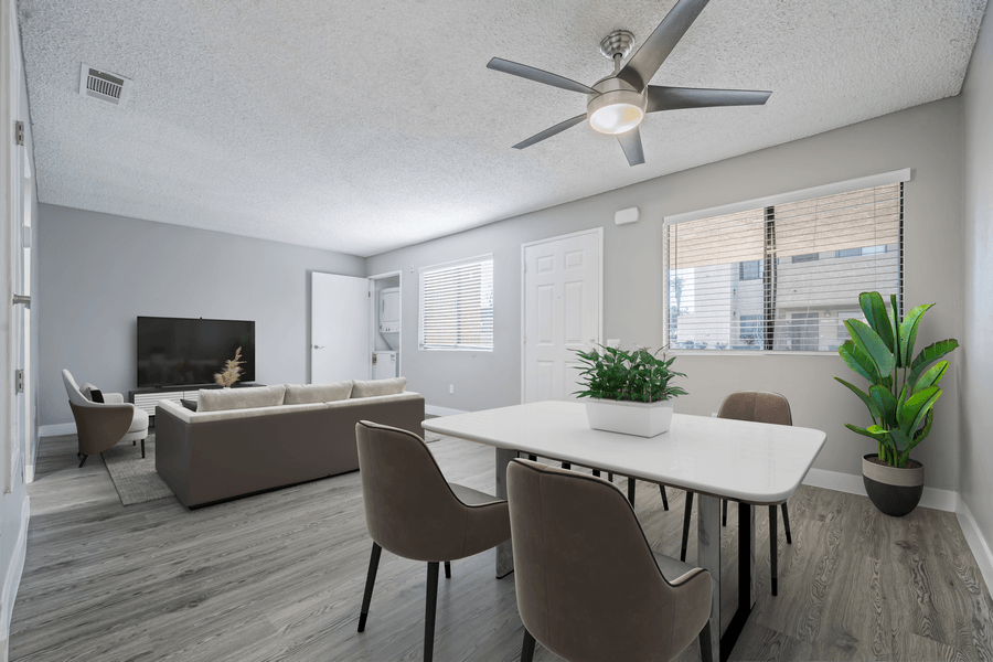 A living room with a white table and brown chairs.