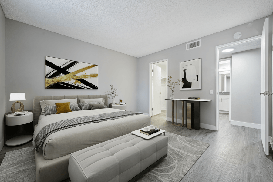 A modern bedroom with a large bed and a painting on the wall.