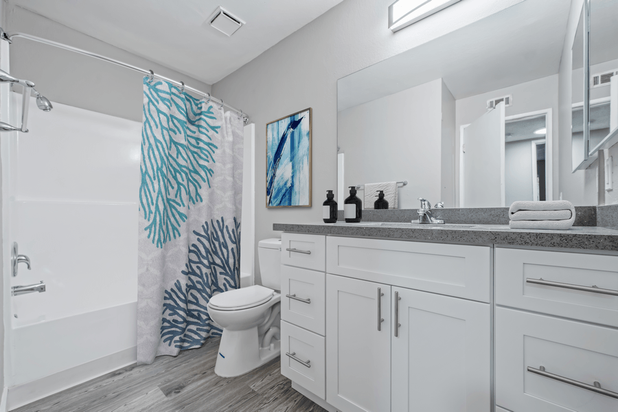 A bathroom with a white toilet, sink, and shower curtain.