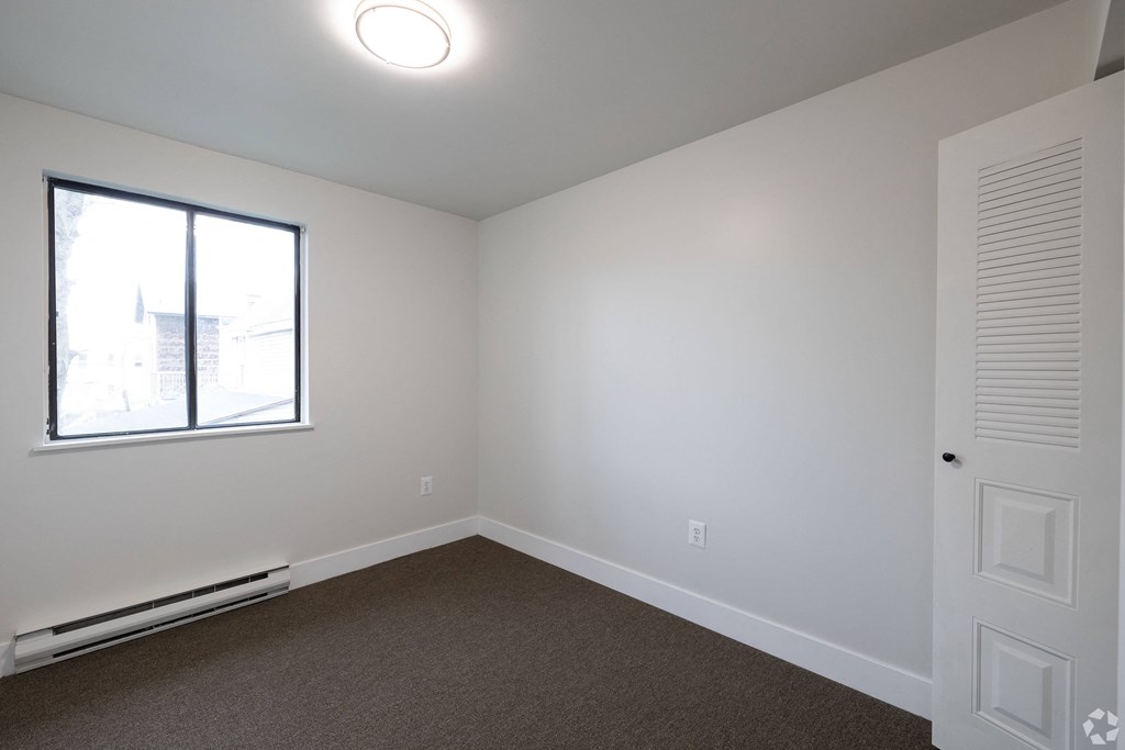 an empty room with carpet and a window