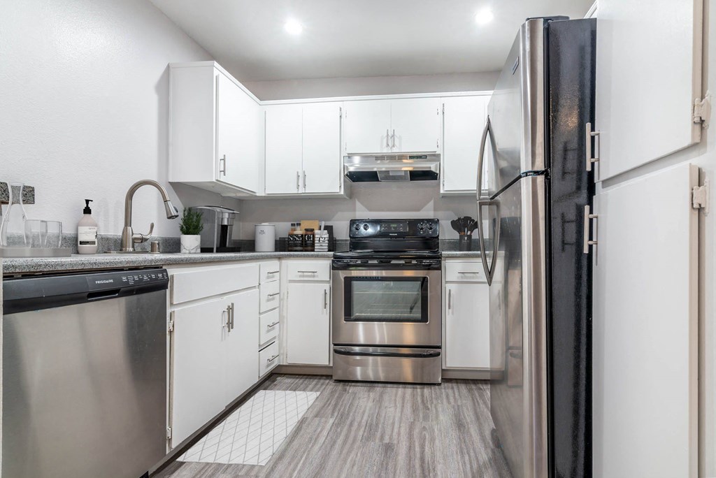 a kitchen with white cabinets and stainless steel appliances