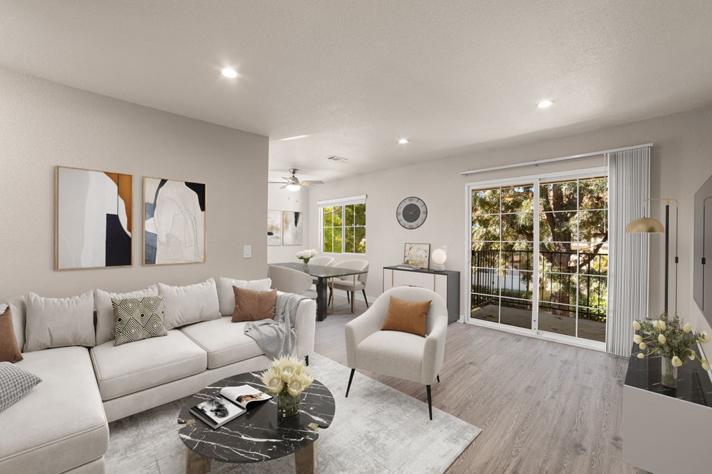 A modern living room with a white sofa, a coffee table, and a large window.