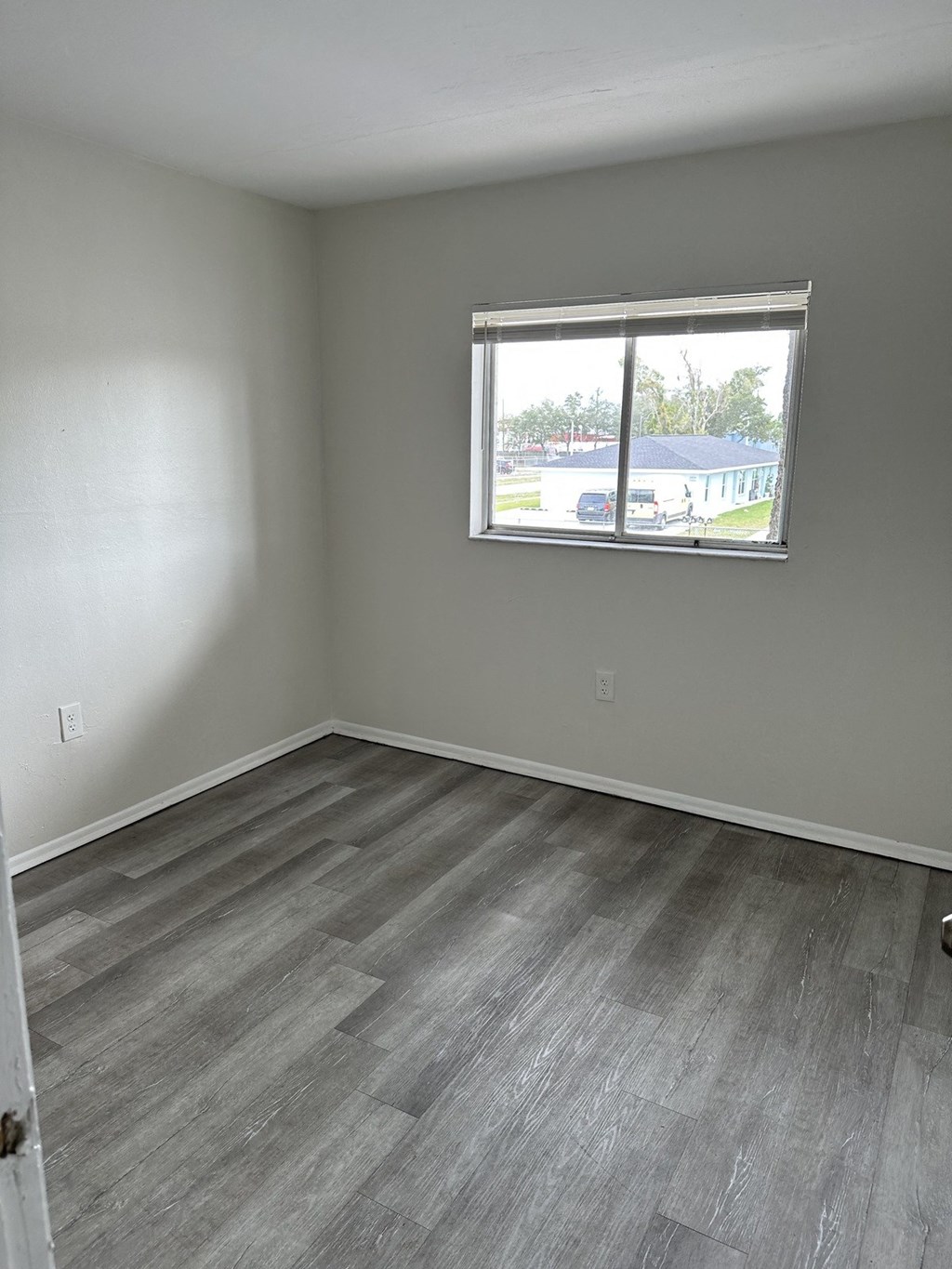 an empty room with wooden floors and a window