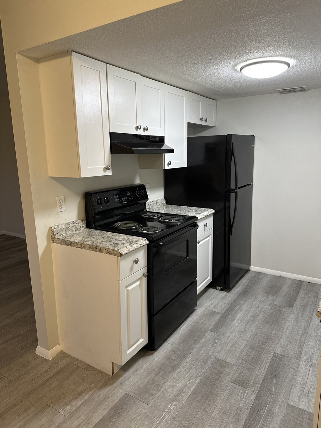 a kitchen with black appliances and white cabinets