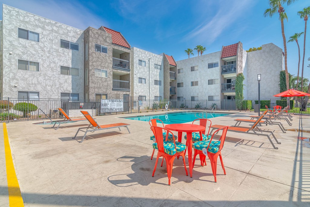 our apartments have a pool and a patio with chairs and tables