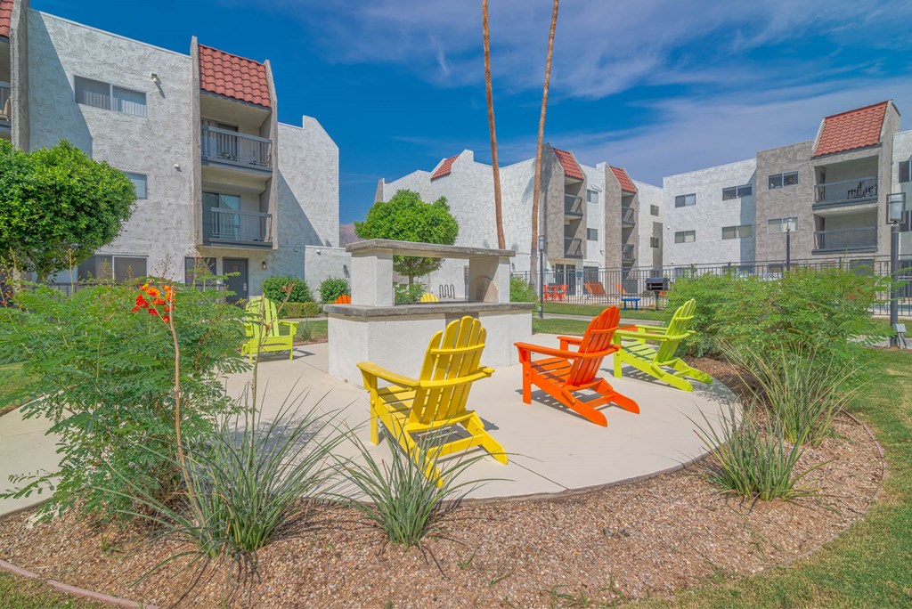 colorful chairs in a courtyard in front of an apartment building