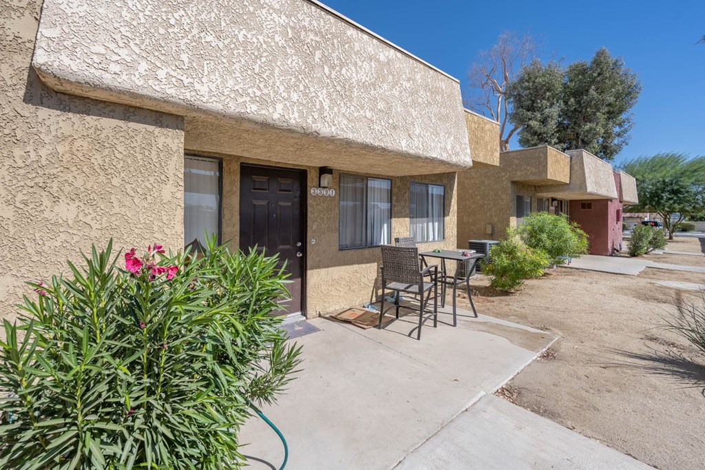 A building with a patio and a table and chairs.