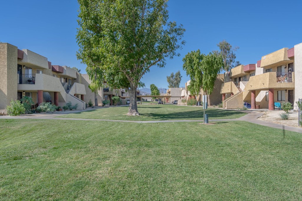 A grassy area in front of apartment buildings.
