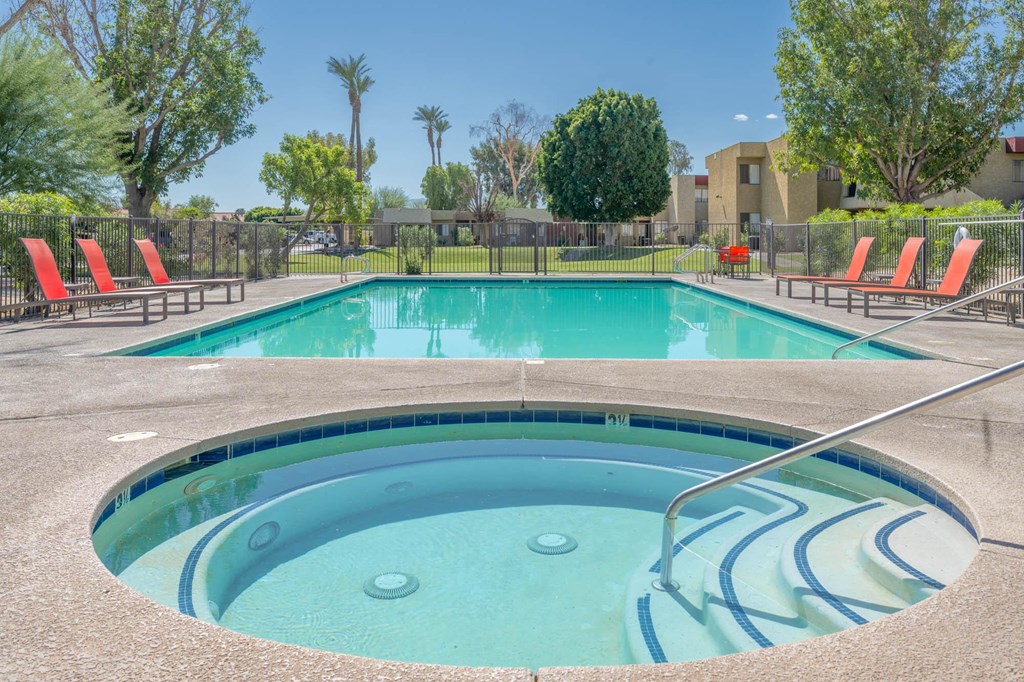 A hot tub sits in the middle of a pool surrounded by chairs.
