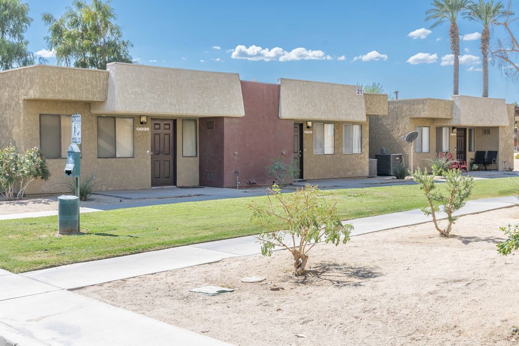 a house with a yard and a sidewalk in front of it