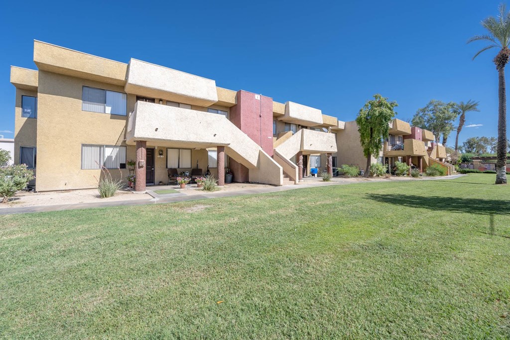 a row of buildings with a green lawn in front of them