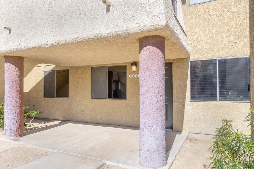 the front of a building with two pillars and a driveway