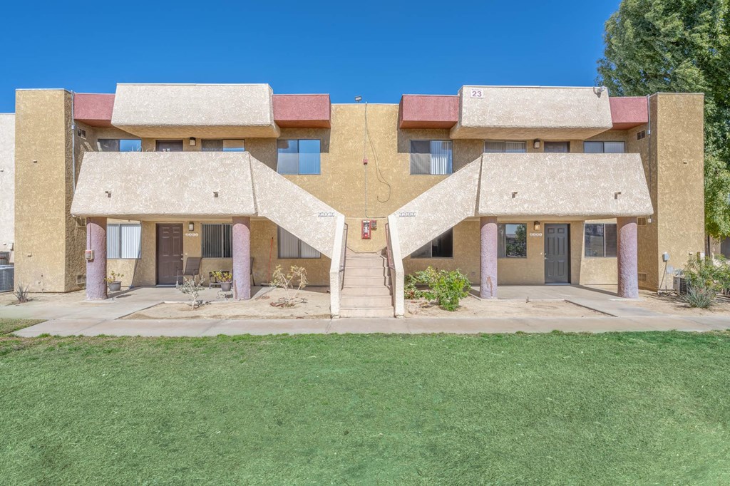 a large brick building with a lawn in front of it