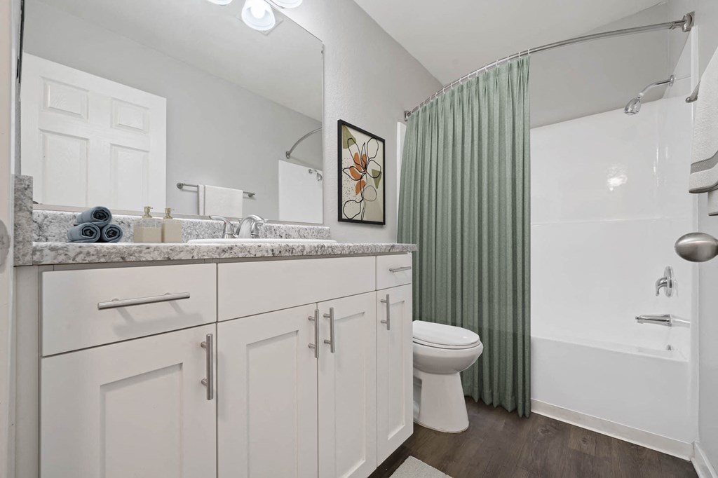 A bathroom with a toilet, sink, and shower.