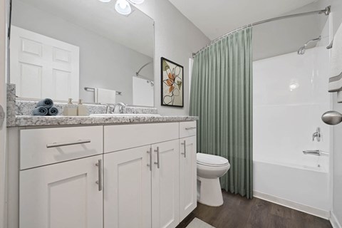 A bathroom with a toilet, sink, and shower.