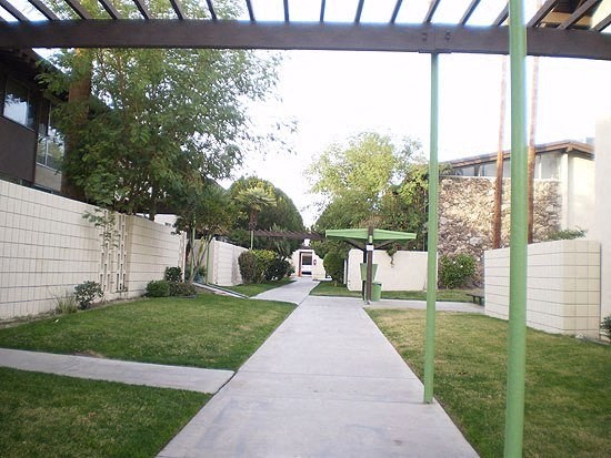 a white van driving down a sidewalk next to a fence