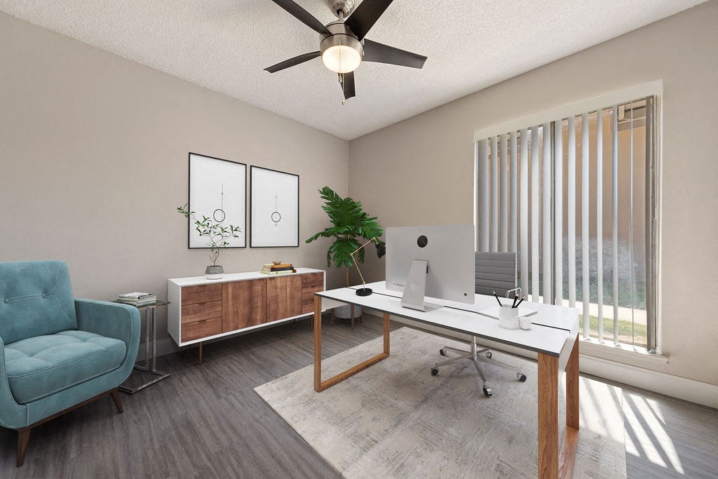 our apartments offer a spacious living room with a desk and a ceiling fan