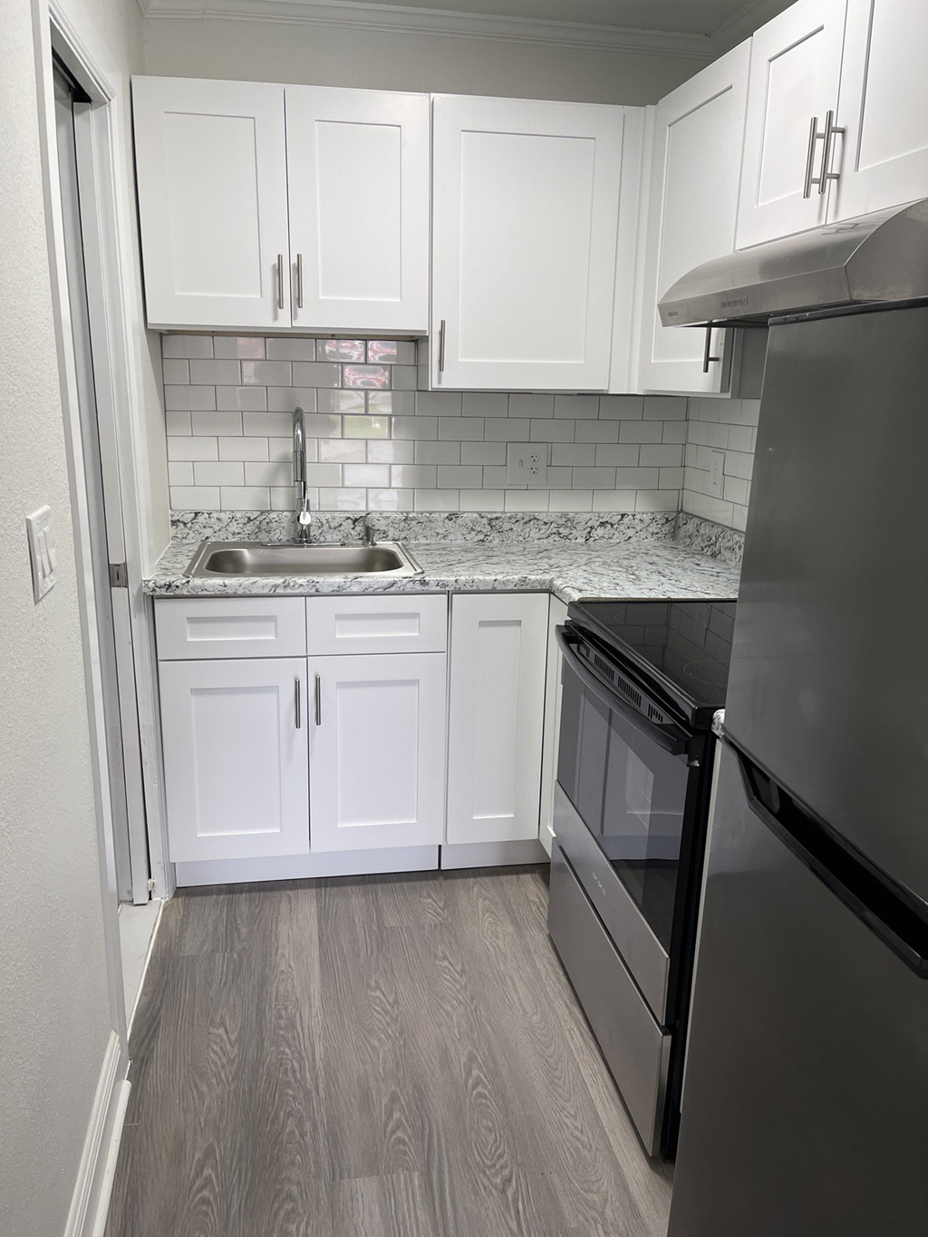 a kitchen with white cabinets and black appliances