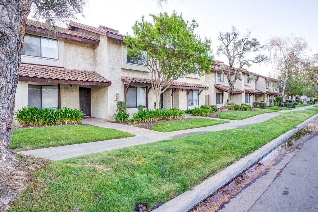 a row of houses on the side of a sidewalk