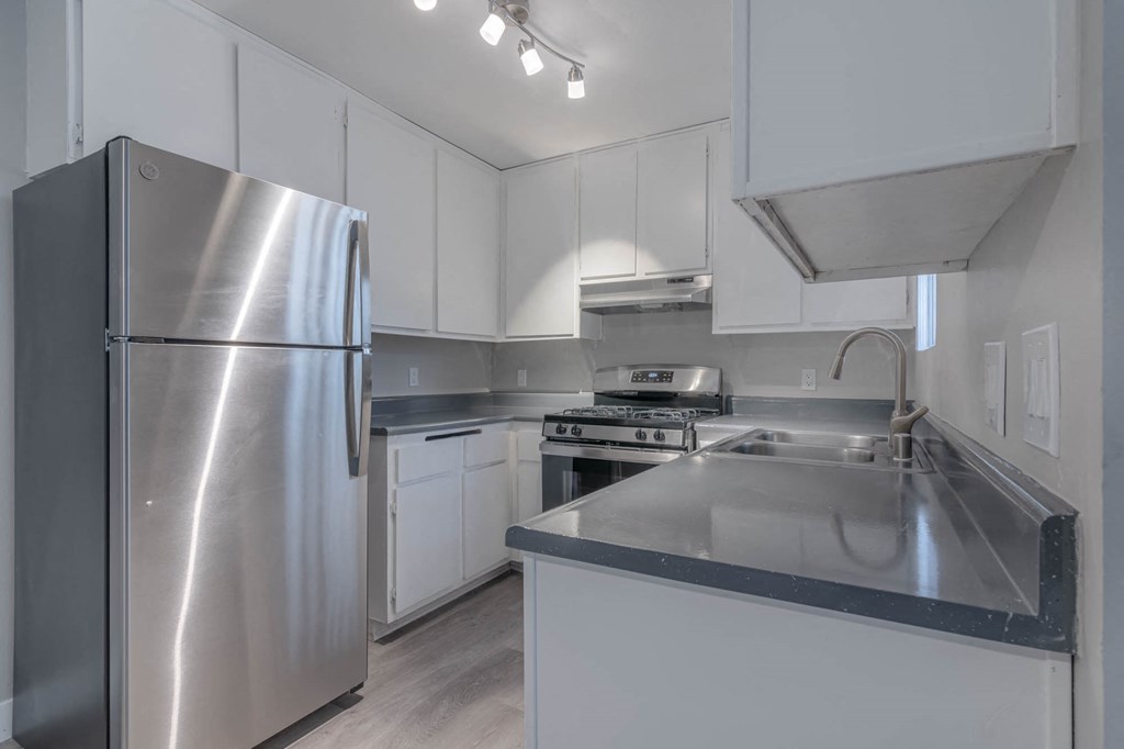 a kitchen with white cabinets and stainless steel appliances